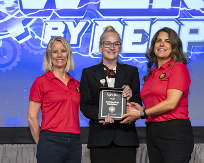 A student poses with their award plaque between two NBCOT staff members