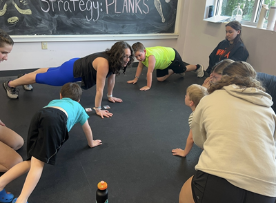 Adults and children in a plank pose.