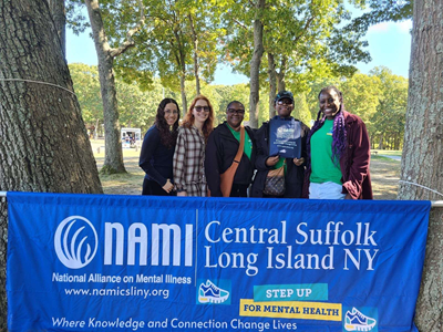 Five people stand outside behind a blue banner—NAMI Central Suffolk Long Island NY.