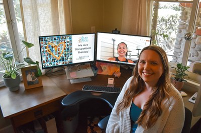 A woman smiles at the camera; a virtual meeting setup is in the background.