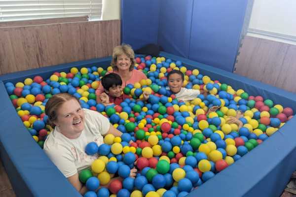 Stephanie in a ball pit with kids from her practice 